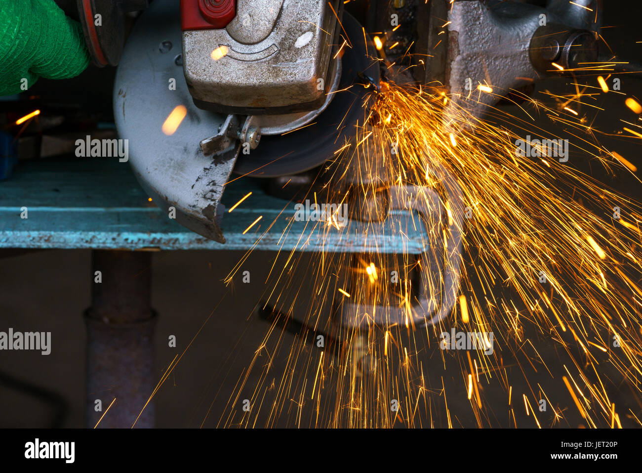 Angular grinding machine is cutting the metal and a lot of sparks flying around Stock Photo