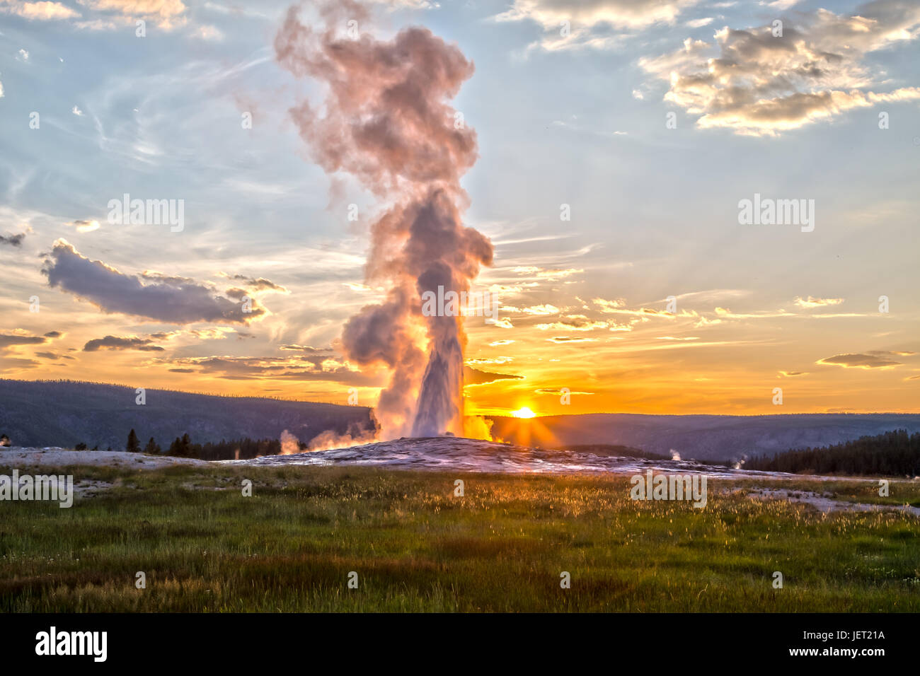 Old Faithful Geyser Eruption in Yellowstone National Park at Sunset Stock Photo