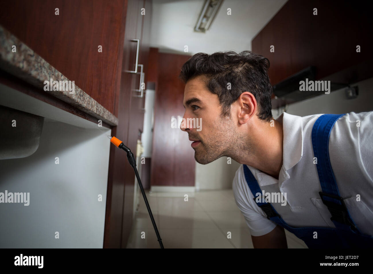 Manual worker concentration below sink Stock Photo