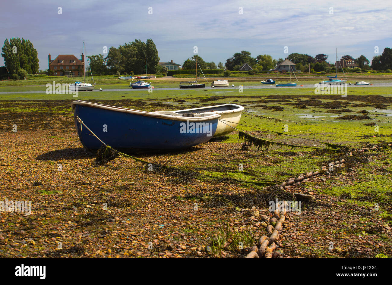 Open boats grounded at low tide in the historic harbour at Bosham in West Sussex in the South of England Stock Photo