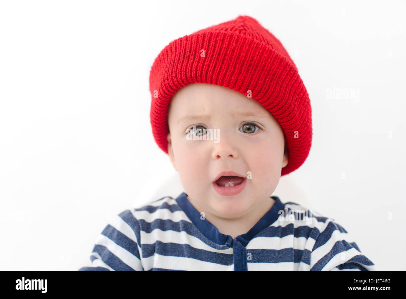 Kid in red hat is indignant two first teeth studio on a white background Stock Photo