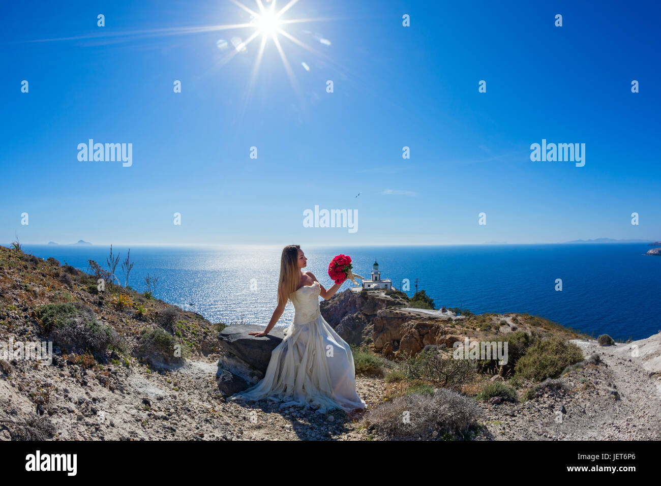 Beautiful woman in white dress on a stone near the sea Stock Photo - Alamy