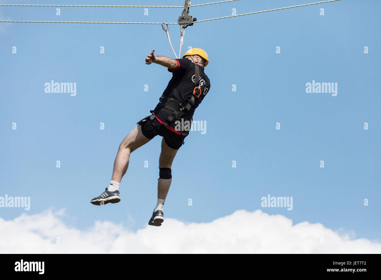 DOBRIS, CZECH REPUBLIC - JUNE 10, 2017. The man in the seat crashes down the rope across the valley. Centre harness Stock Photo