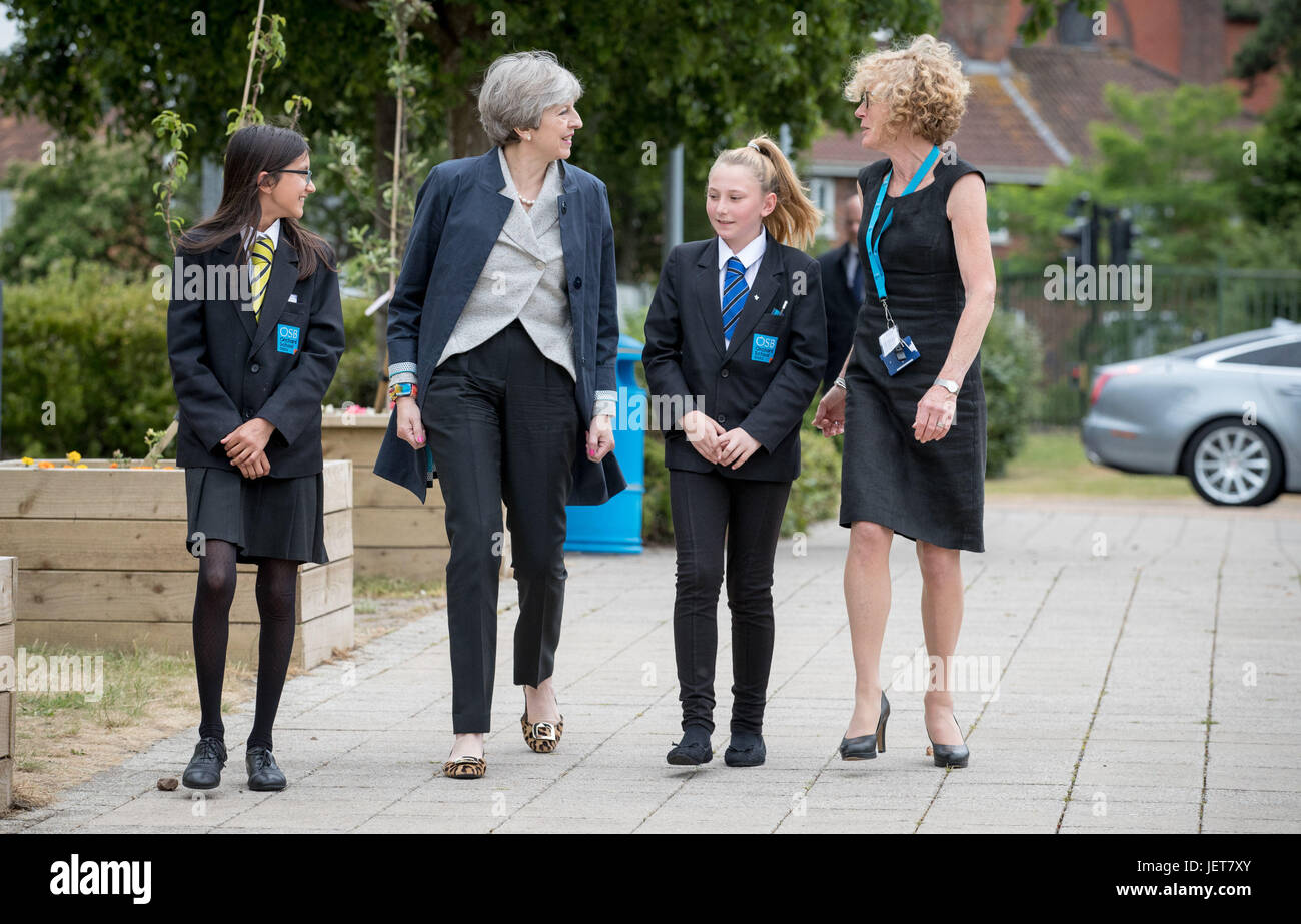 Prime Minister Theresa May walks with pupils Miya Herbert (left) Katie Davies (right) and head teacher Dr Helen Holman as she arrives for a session for teachers receiving training in mental health support at Orchard School in Bristol. Stock Photo