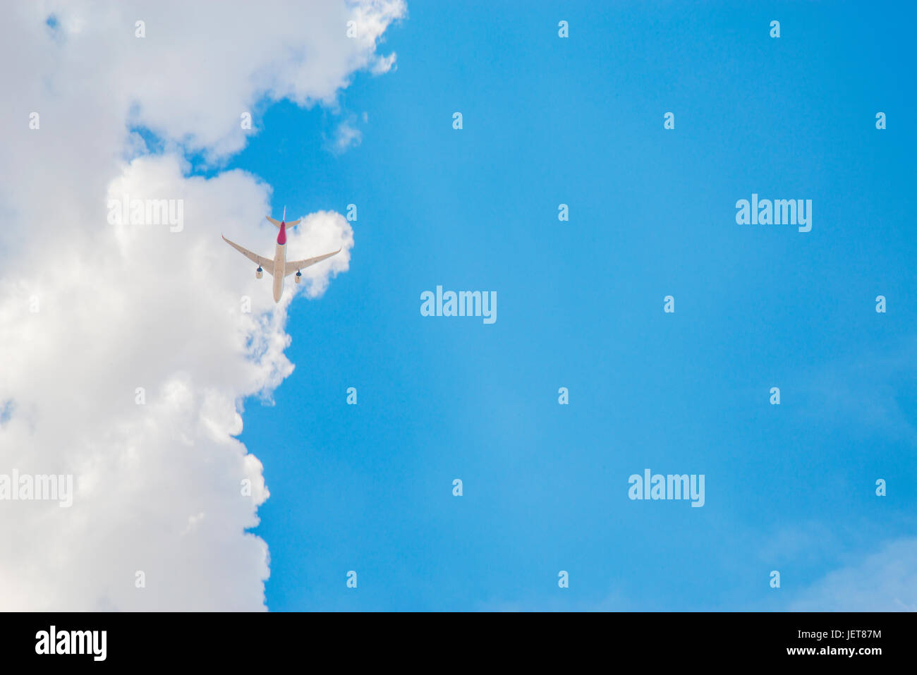 Airplane flying against cloud and blue sky. Stock Photo
