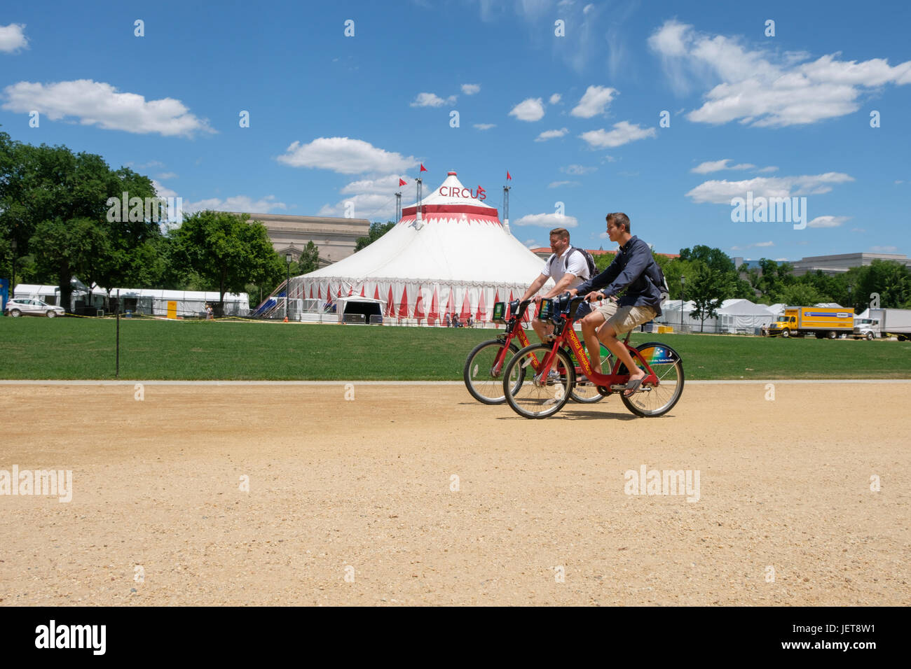 Bicyclists on the National Mall in Washington, DC in front of a circus tent for the Smithsonian Folklife Festival Stock Photo