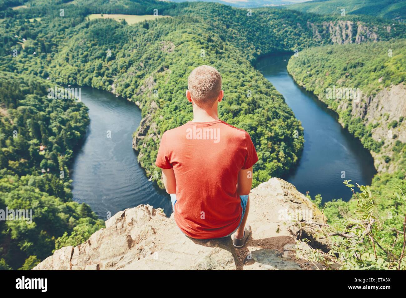 Man on the top of the hill. Young tourist enjoying view on the river. Vltava river, Czech Republic Stock Photo