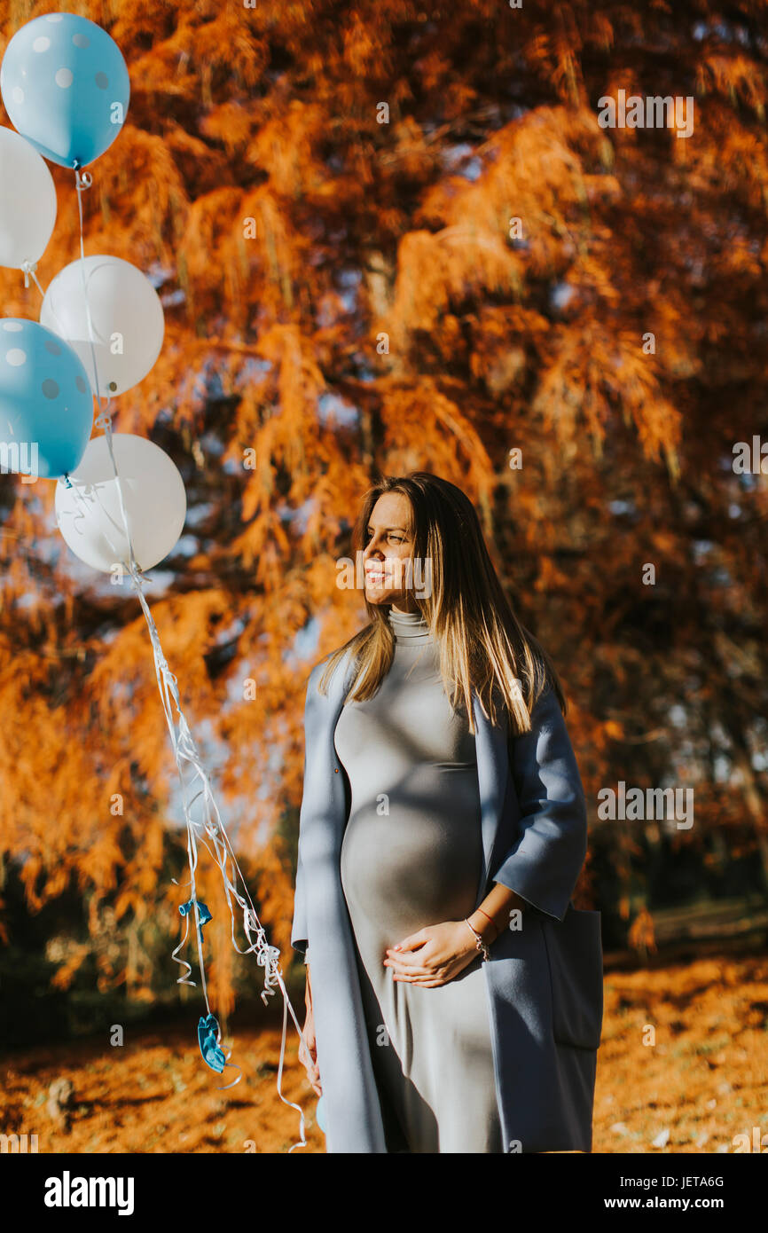 Young pregnant woman walks in autumn park with balloons in hand Stock ...