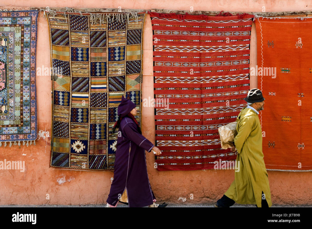 Morocco, Marrakech, Souk, defensive wall, carpets, hang, passers-by, at the side, no model release, Africa, North Africa, destination, culture, trade, economy, market, textiles, people, locals, caftan, couple, go, distance, follow, Stock Photo