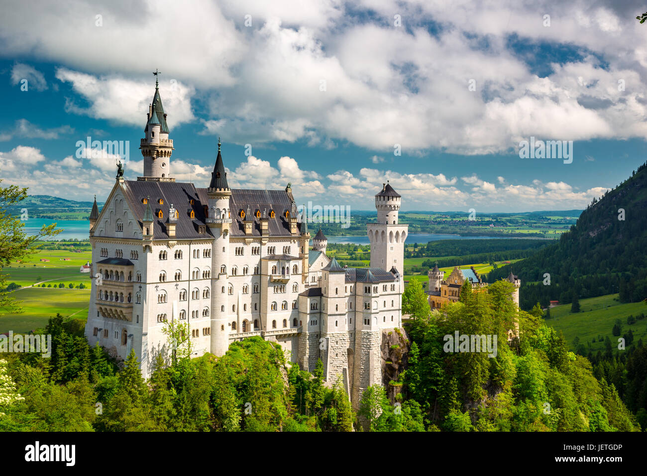 Medieval castle Neuschwanstein. Around the blue sky and the Alps. Beautiful view of the castle. Open landmark and background nature. Stock Photo