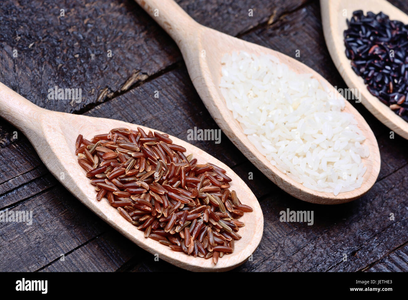 Various types of rice in a wooden spoons on table Stock Photo - Alamy