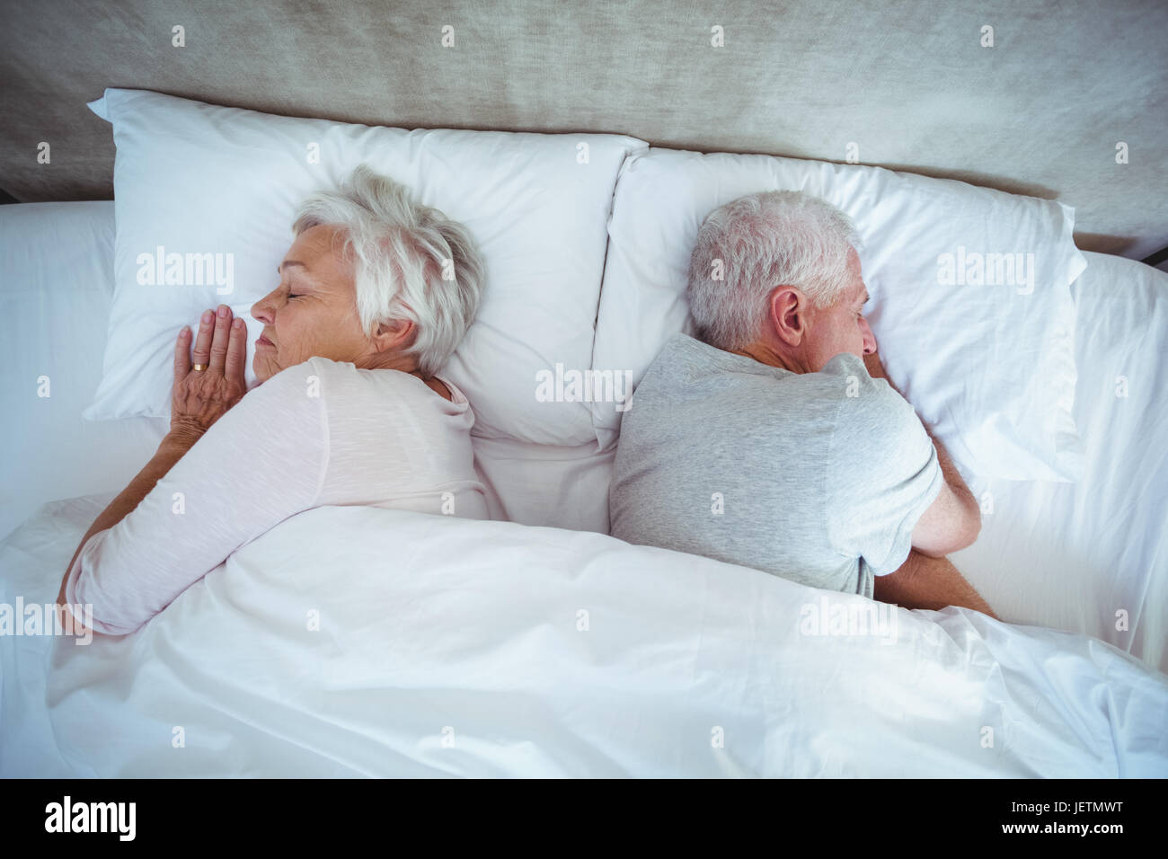 Senior couple sleeping on bed Stock Photo