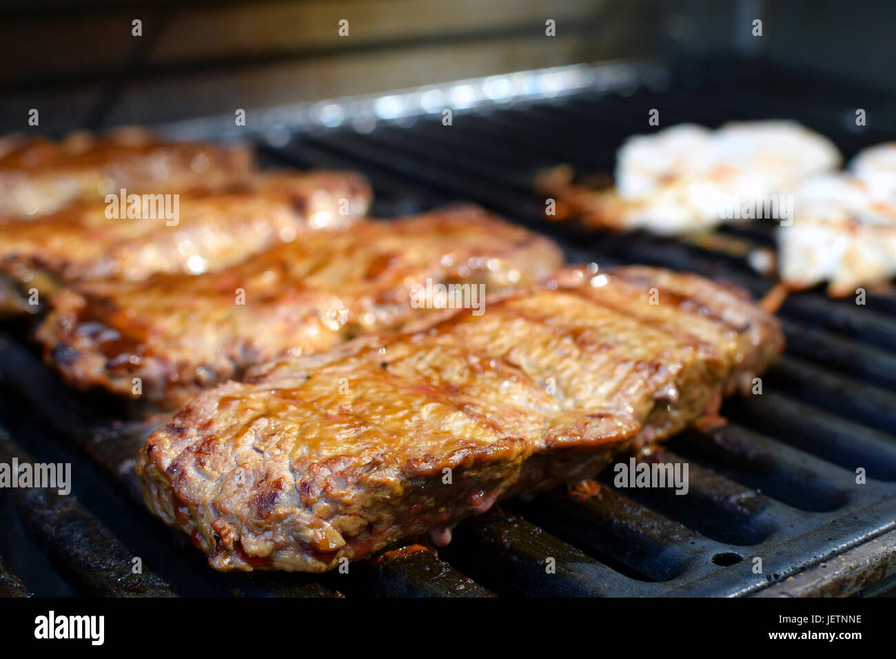 Juicy beef sirloin steaks on barbecue grill. Focus on foreground. Stock Photo