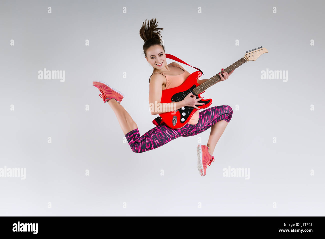 Happy girl with guitar in studio Stock Photo