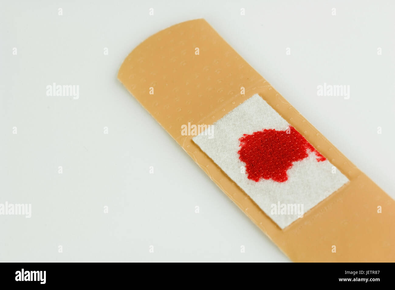 Used sticking plaster with bloodstain, Gebrauchtes Heftpflaster mit Blutfleck Stock Photo