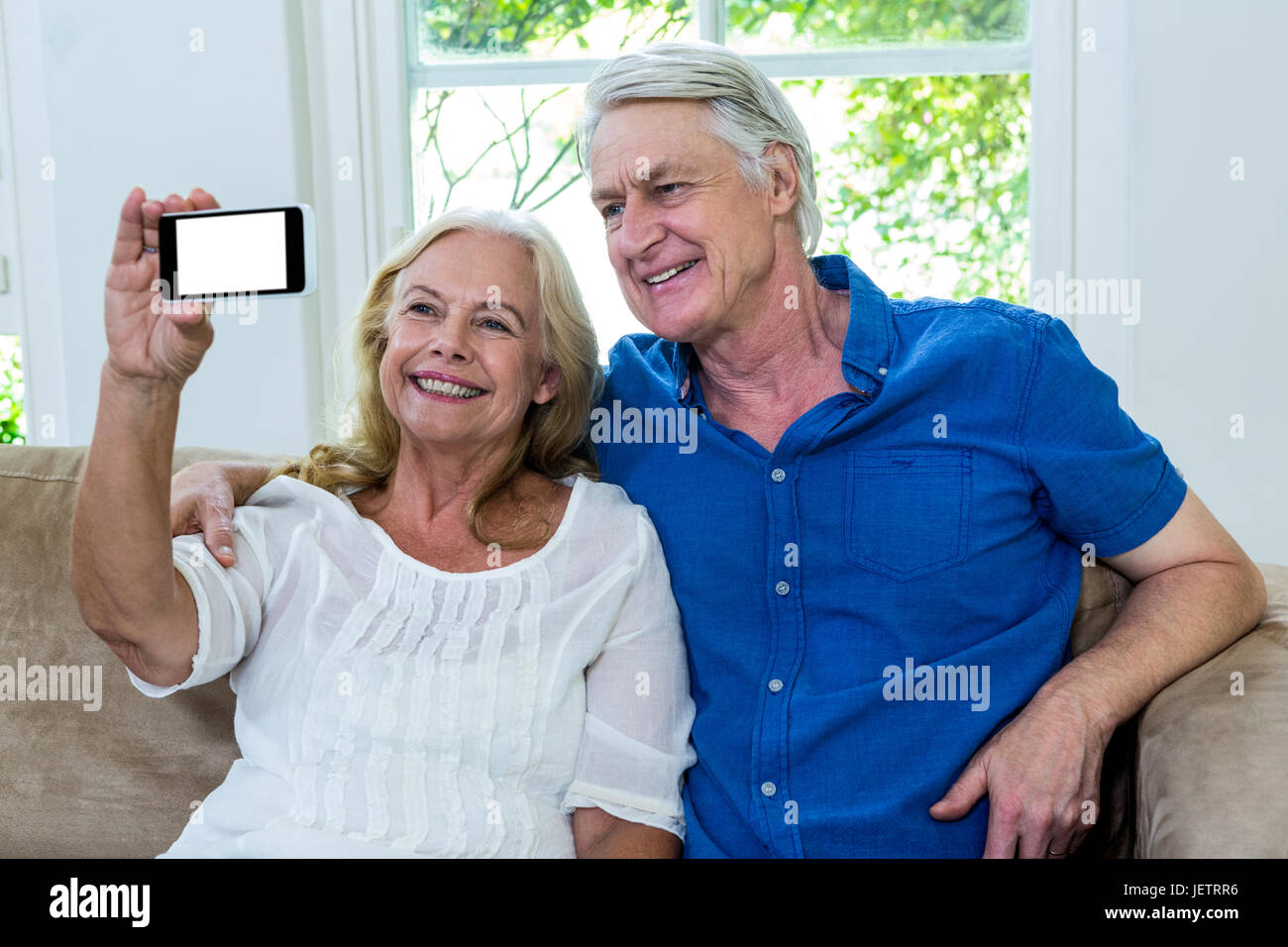 Cheerful senior couple taking selfie at home Stock Photo - Alamy
