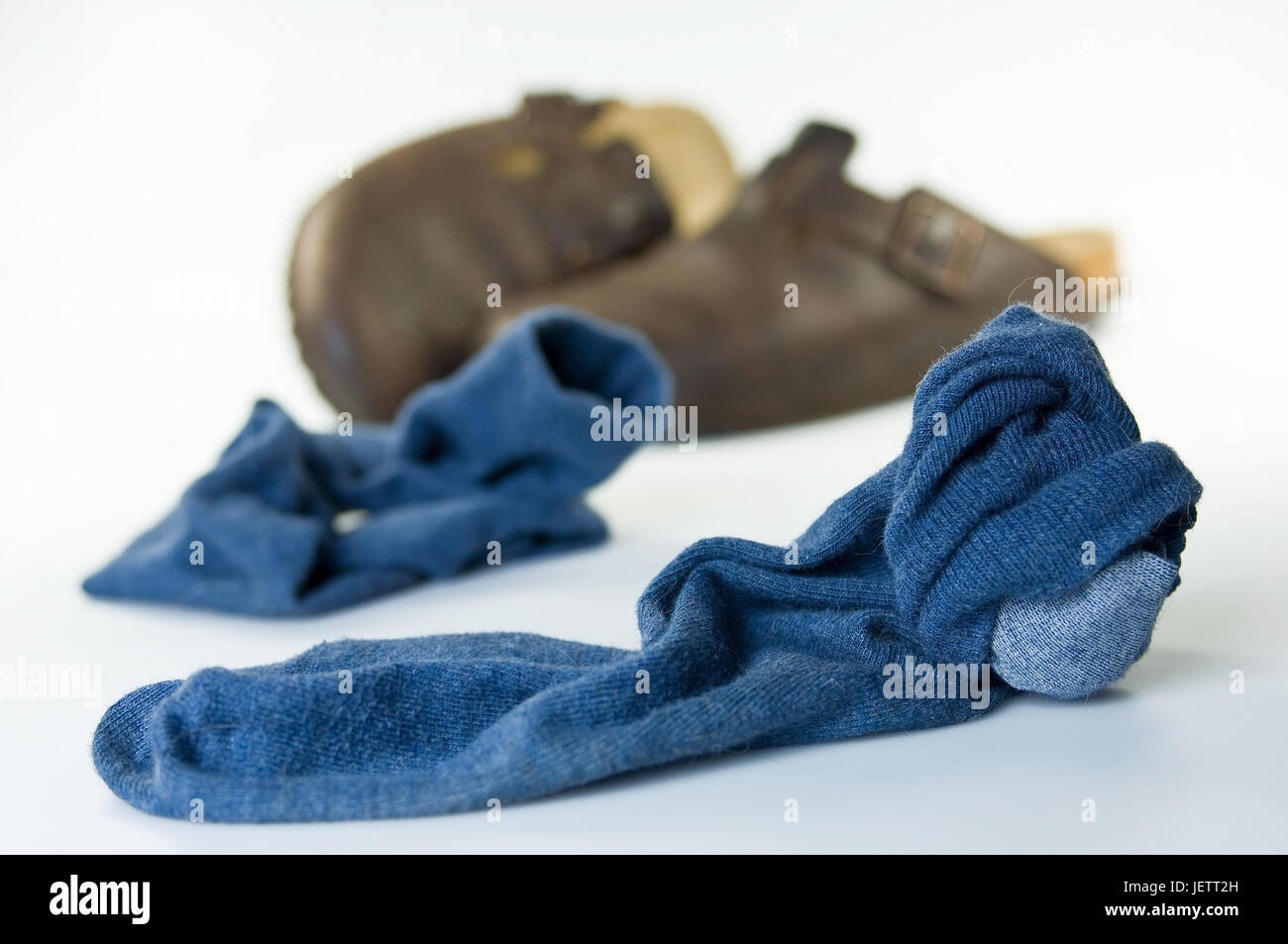 Blue, carried socks and slippers lie on the ground, Blaue, getragene Socken und Hausschuhe liegen auf dem Boden Stock Photo