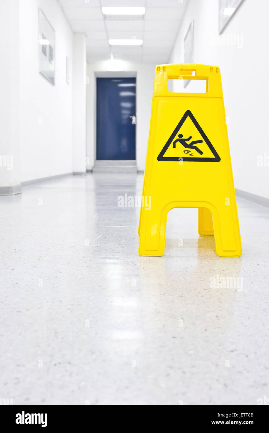'Warning ''care of slide danger'' in a hall', 'Warnschild ''Vorsicht Rutschgefahr'' in einem Korridor' Stock Photo