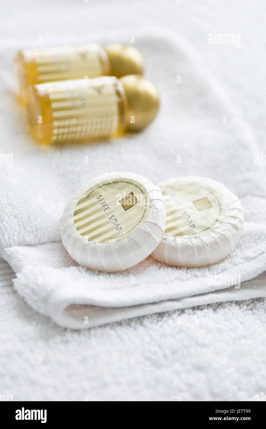 Shower gel and soap on a pile of white towels and washcloths, Duschgel und Seife auf einem