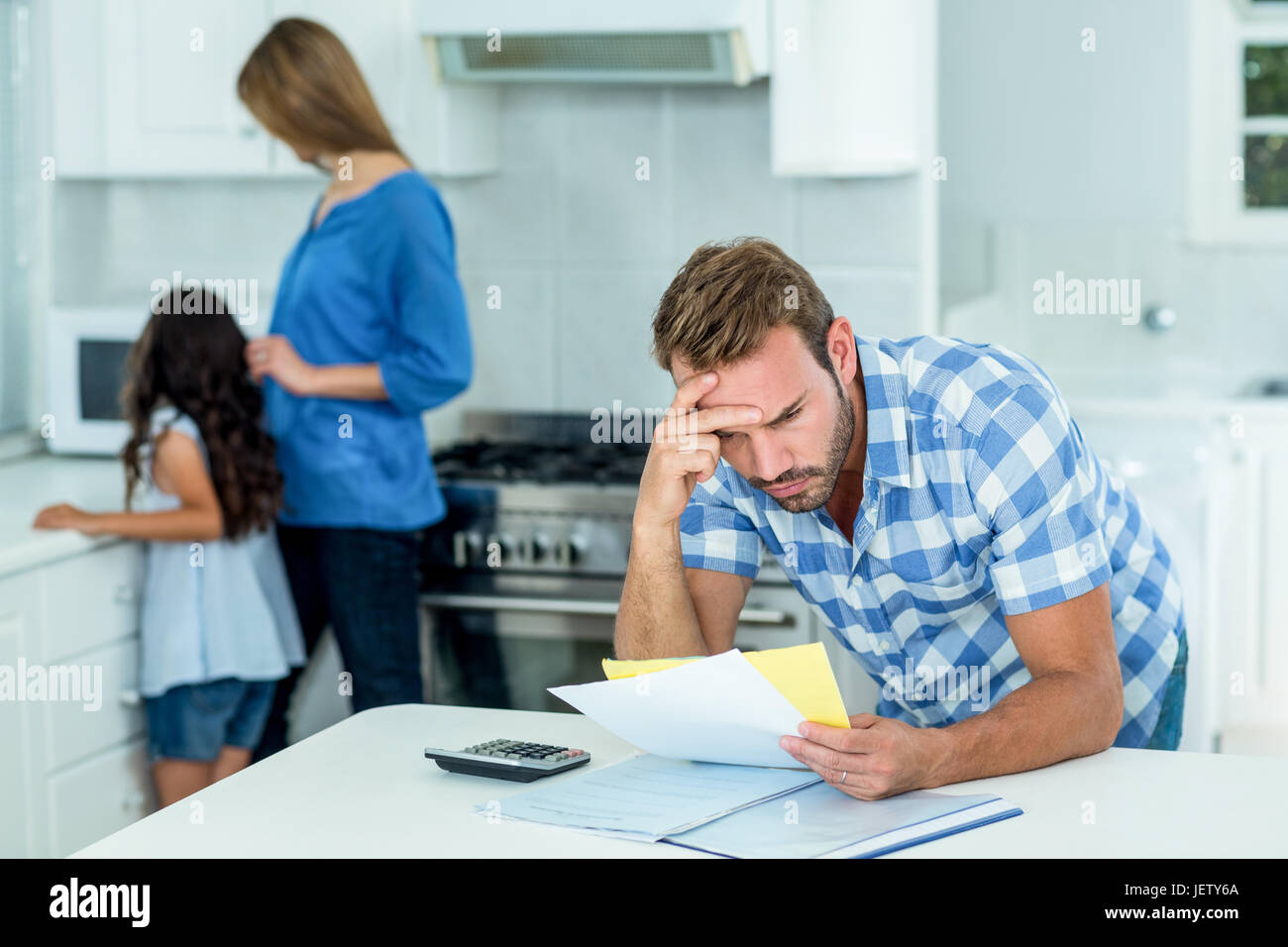 Worried father looking at bills at home Stock Photo