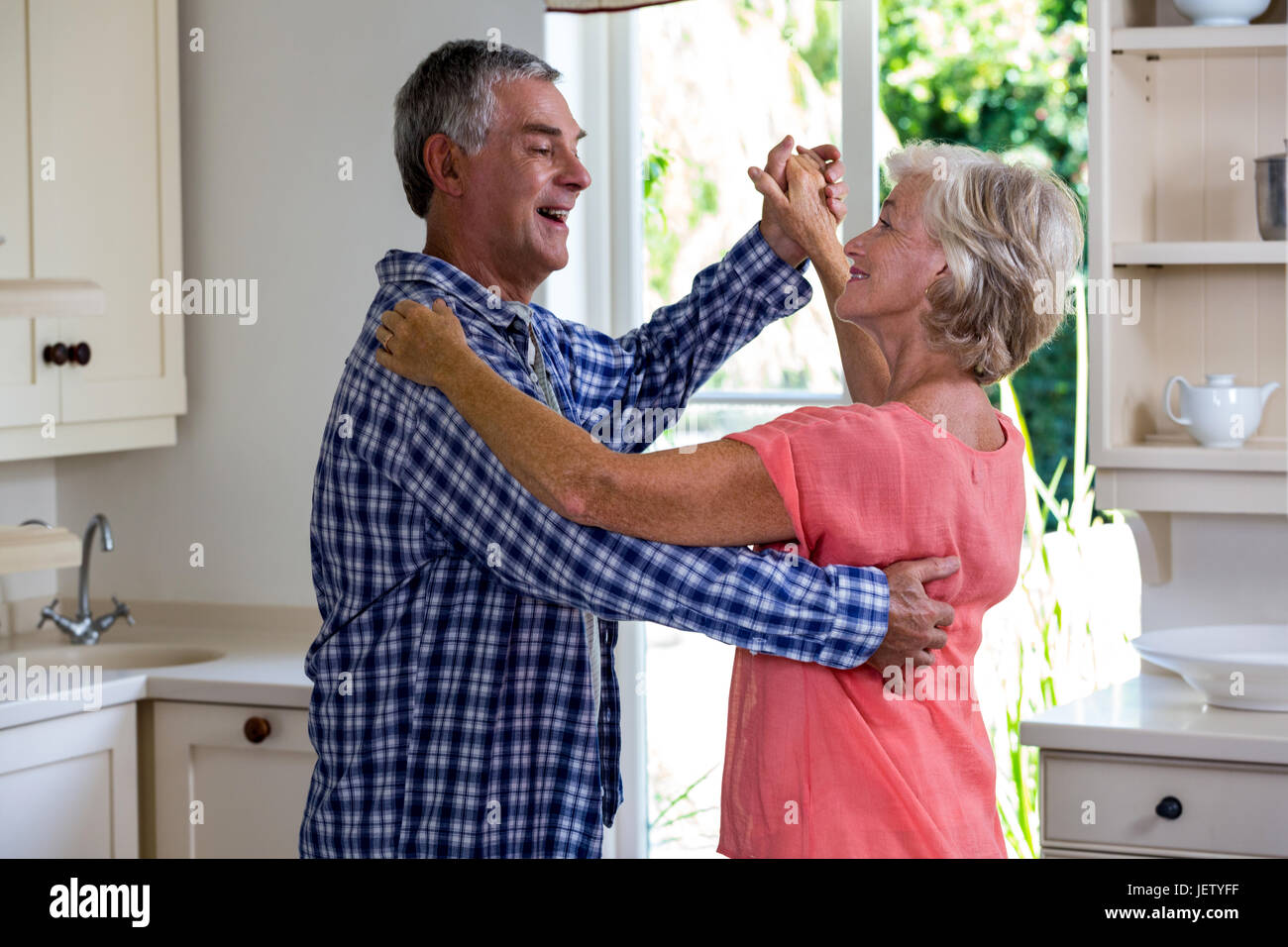 Happy senior couple dancing in kitchen Stock Photo - Alamy