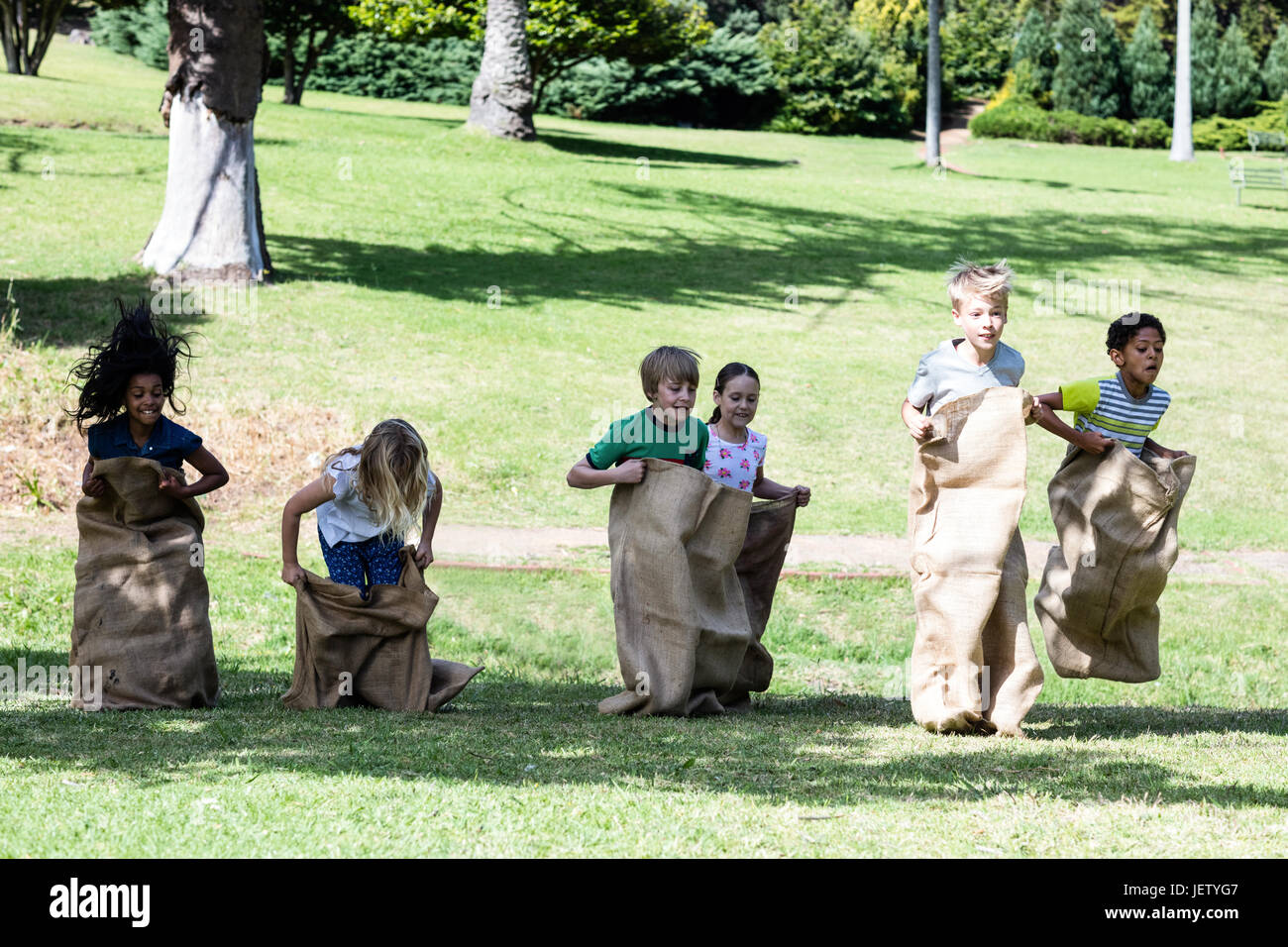 Children having a sack race in park Stock Photo Alamy