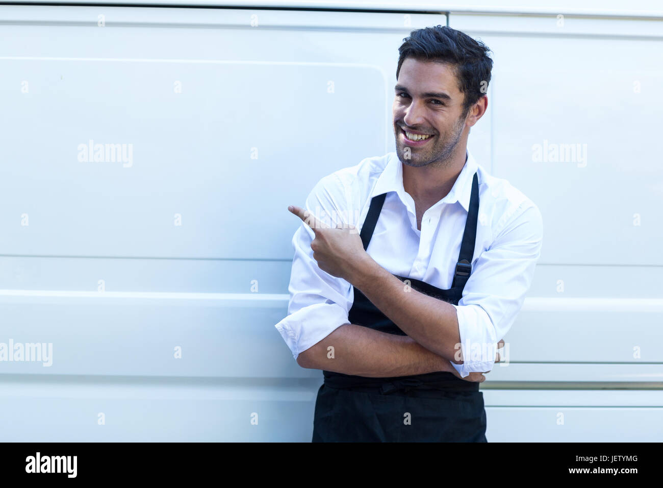 Smiling delivery man pointing van hi-res stock photography and images ...