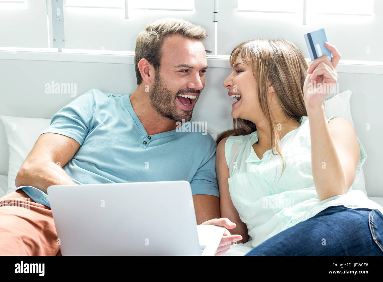 Couple using laptop on bed at home Stock Photo - Alamy