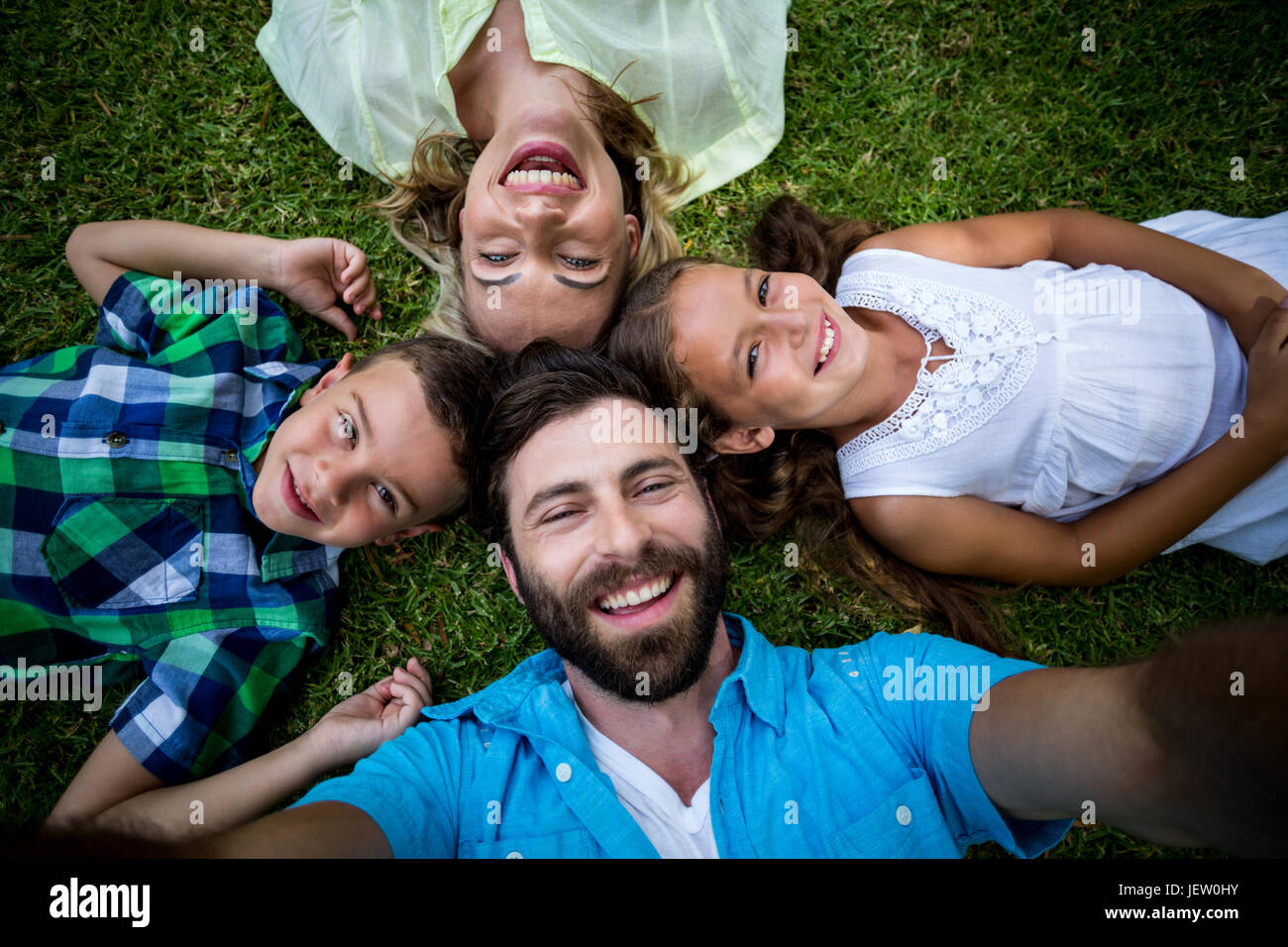 Cheerful family lying on grass in yard Stock Photo - Alamy