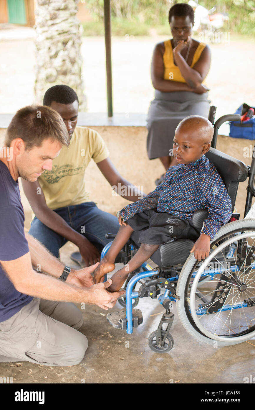 An expat physical therapist helps a boy with club feet in Bundibugyo, Uganda. Stock Photo