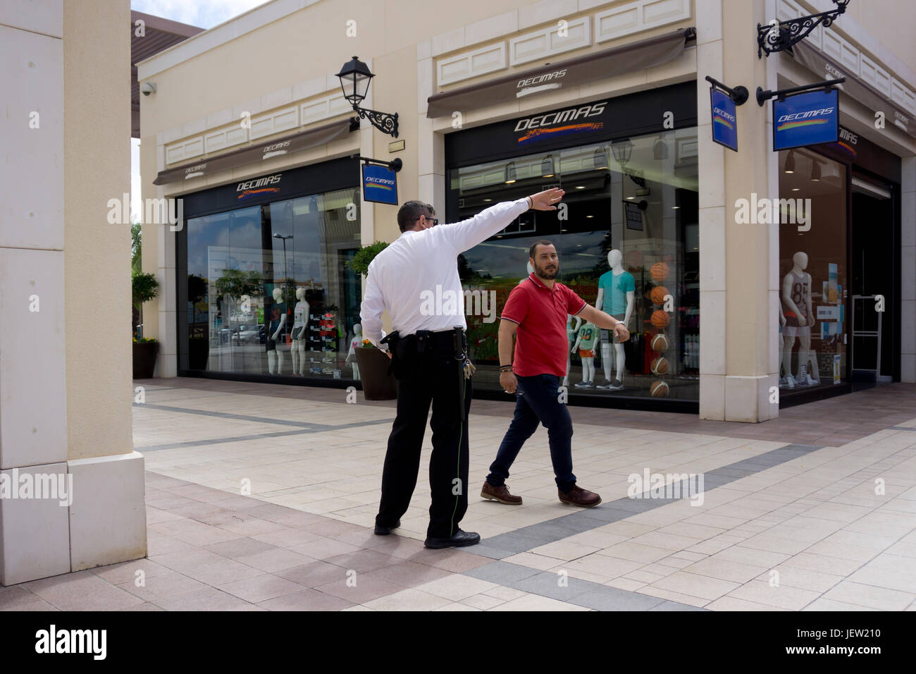 Security guard in a shopping centre giving directions Stock Photo