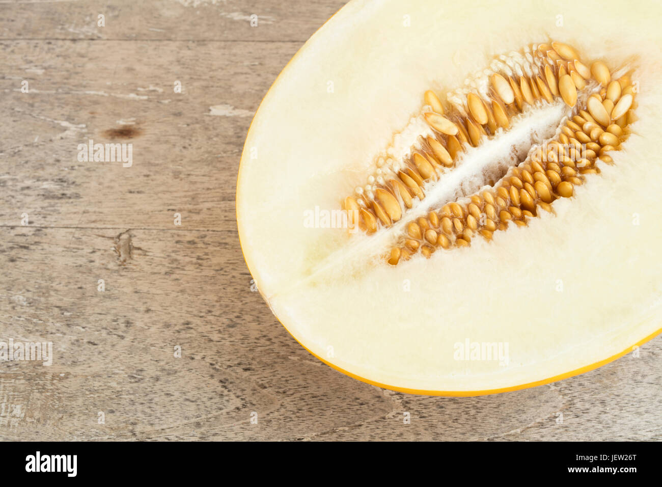 Detail of a sliced yellow melon a a wooden table Stock Photo