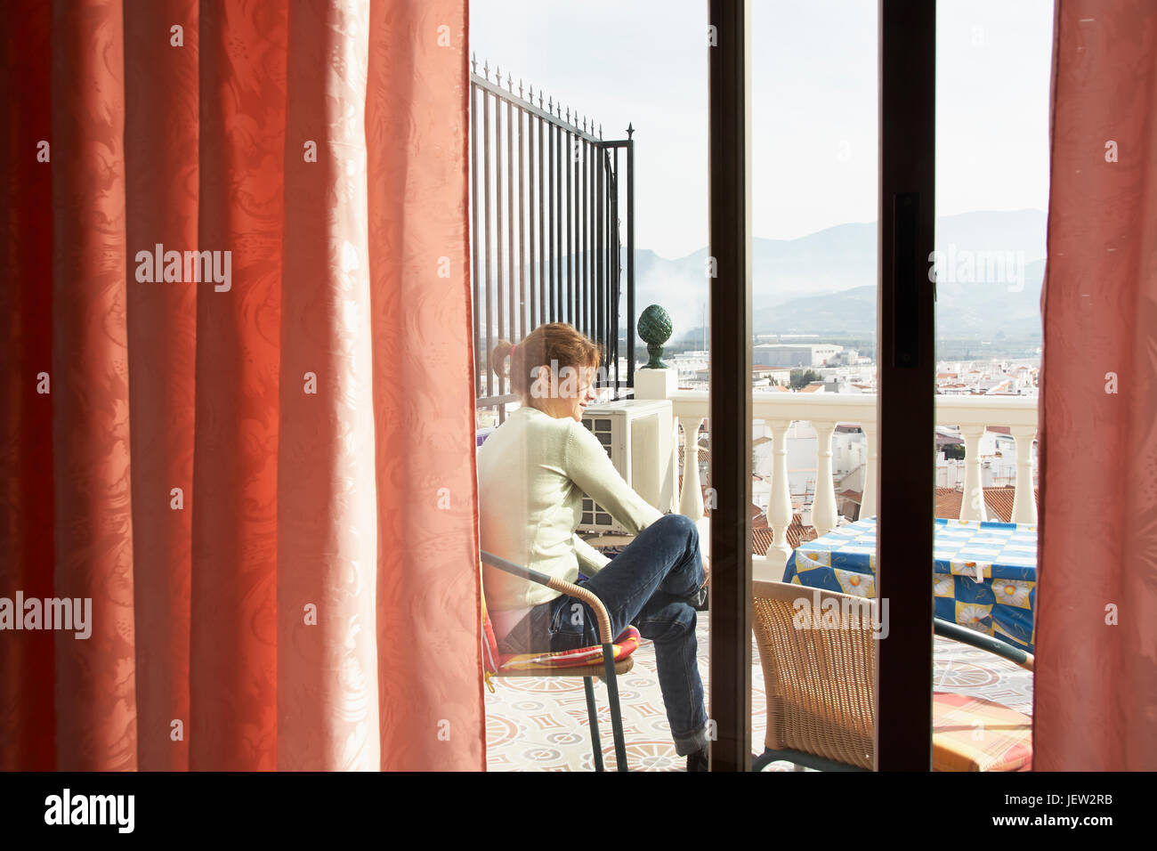Young woman sitting on terrace Stock Photo - Alamy