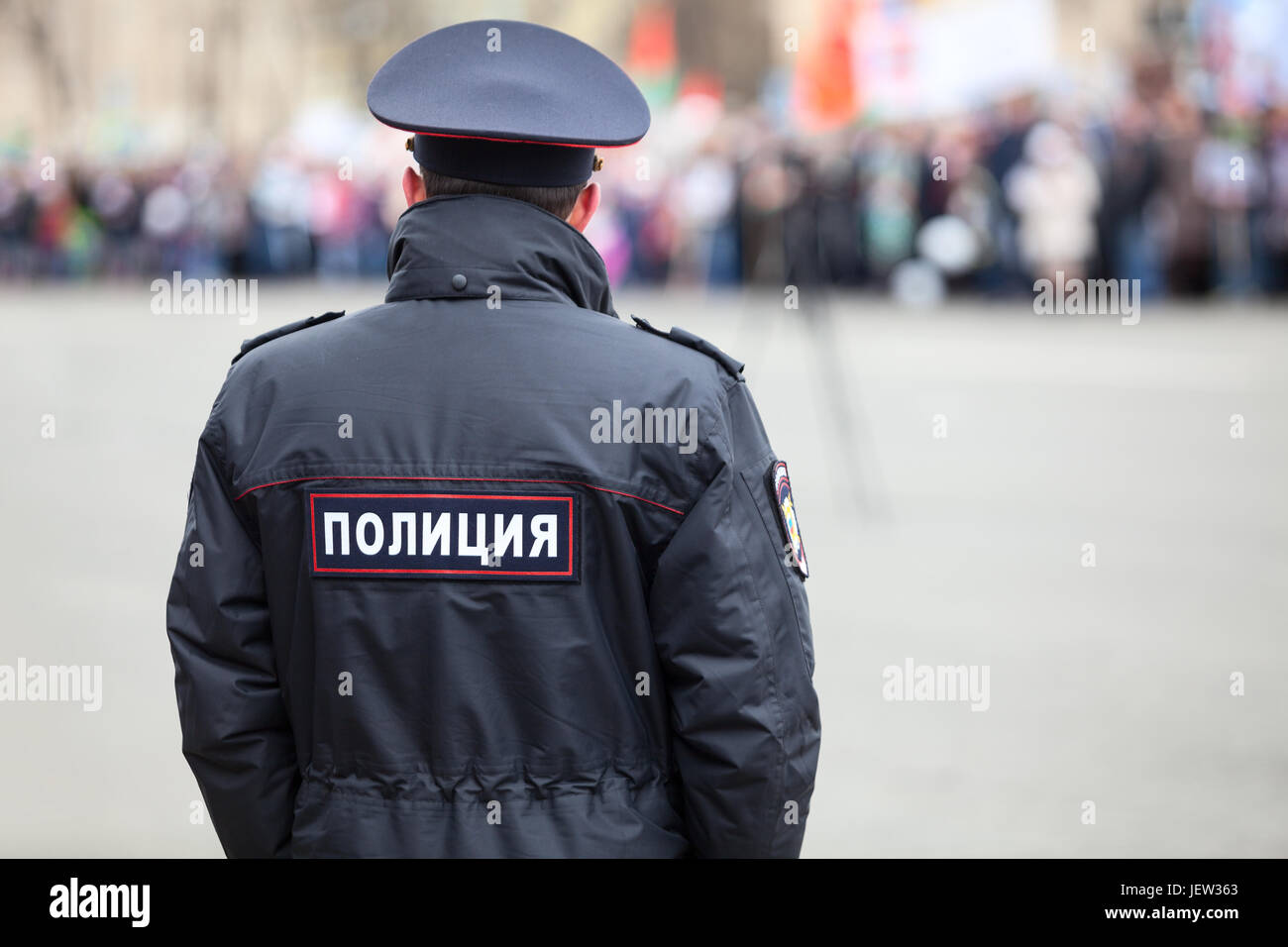Russian policeman officer stands to opposite crowd with inscription Police  on the uniform jacket, Russia, copy space Stock Photo - Alamy