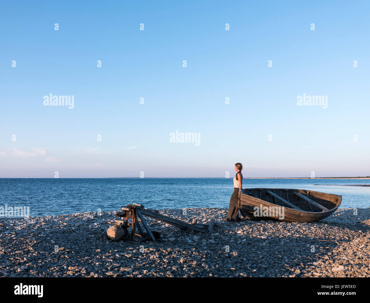 Woman on beach looking at sea Stock Photo - Alamy