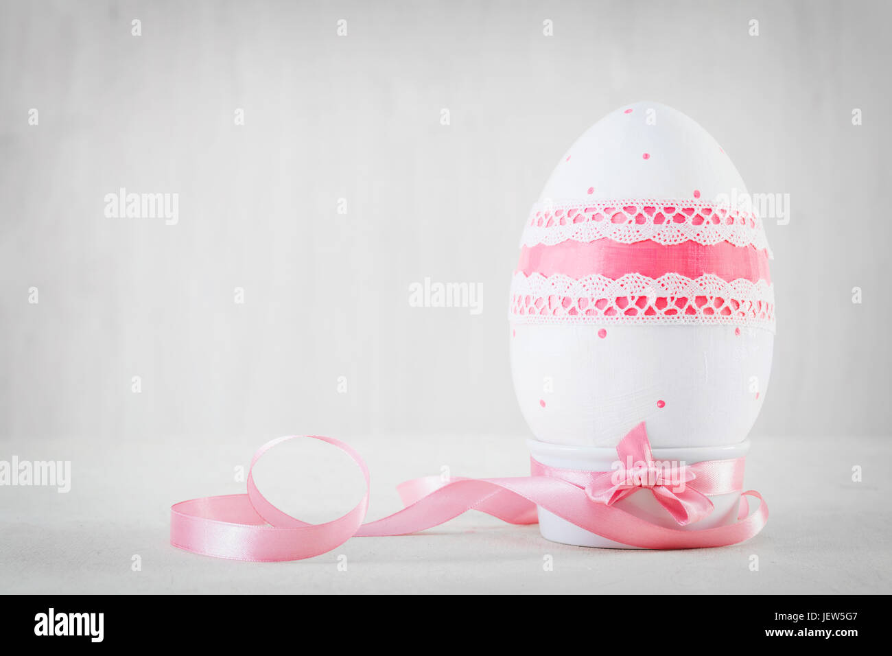 Single easter handmade egg on wooden white table. Decoupage art, pastel tone Stock Photo