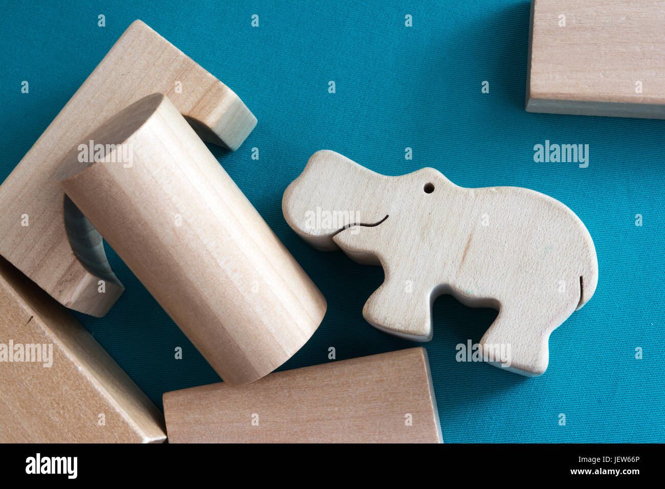 Eco children toys scattered. Wooden blocks and hippo on blue background Stock Photo
