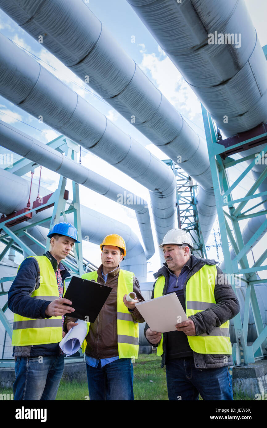 Engineers discussing maintenance of a petrochemical plant. Technical