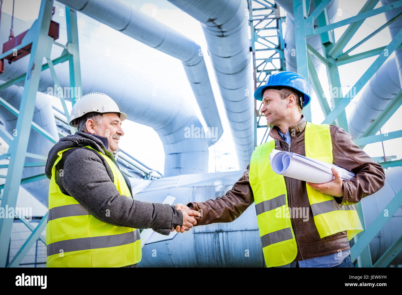 Oil refinery engineers handshake. Petrochemical and gas industry ...