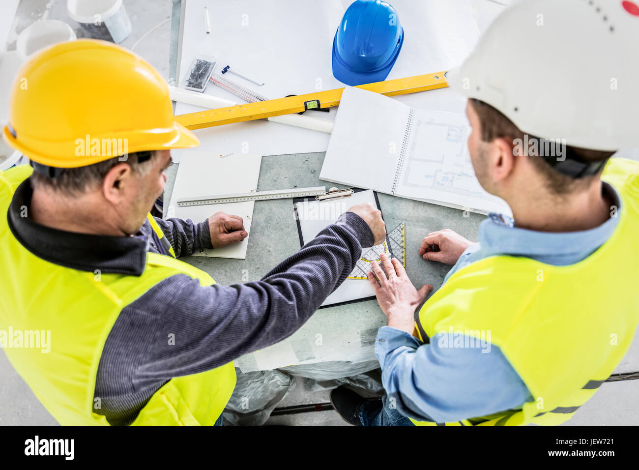 Architect and construction engineer indoor meeting. Building experts cooperation and project analysis. Discussing blueprint data. Real estate market. Stock Photo