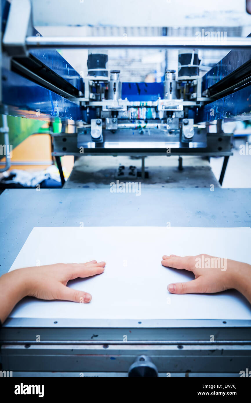 Worker preparing print screening metal machine. Industrial printer. Manufacture work. First person perspective. Stock Photo