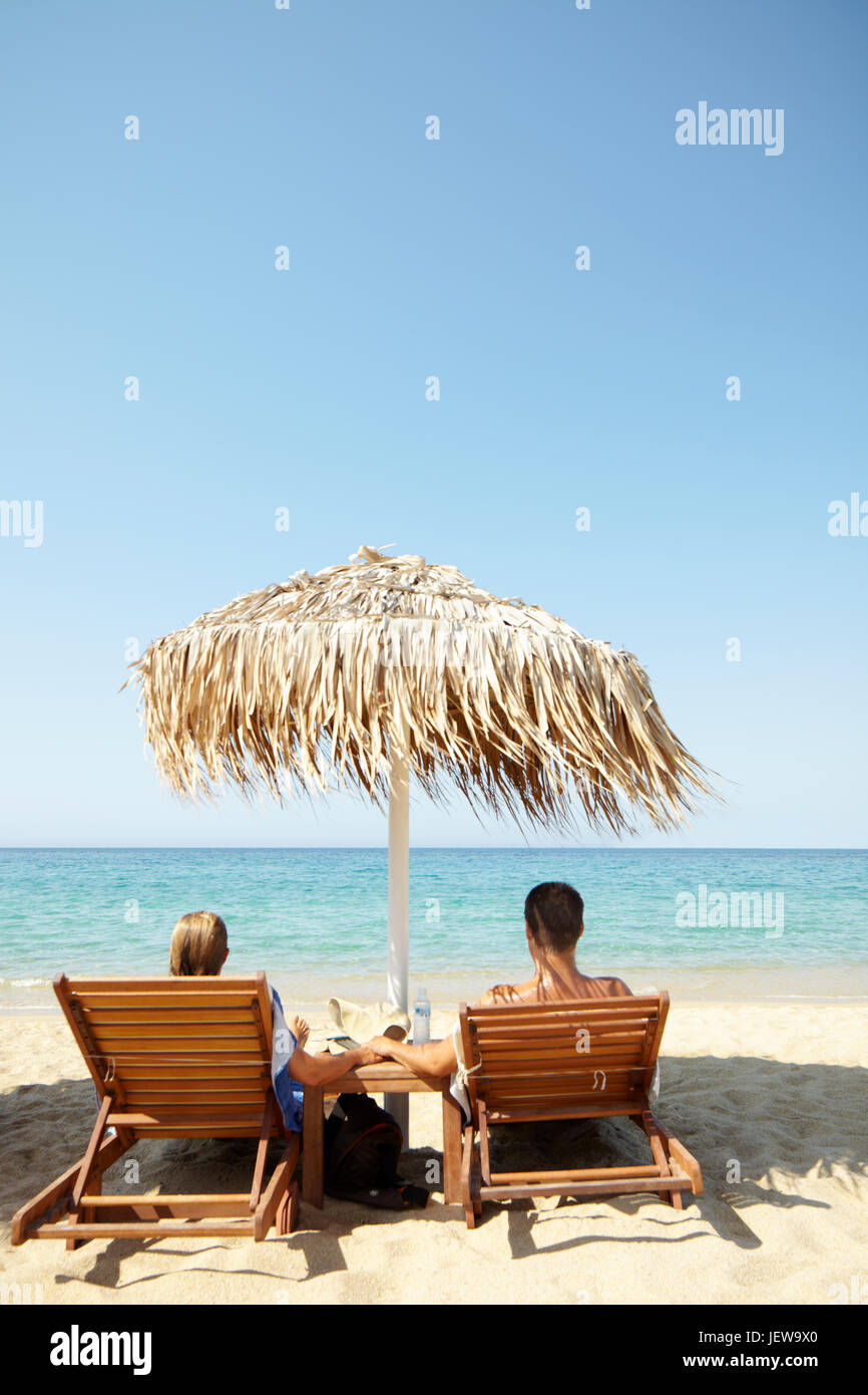 Couple relaxing on beach Stock Photo - Alamy