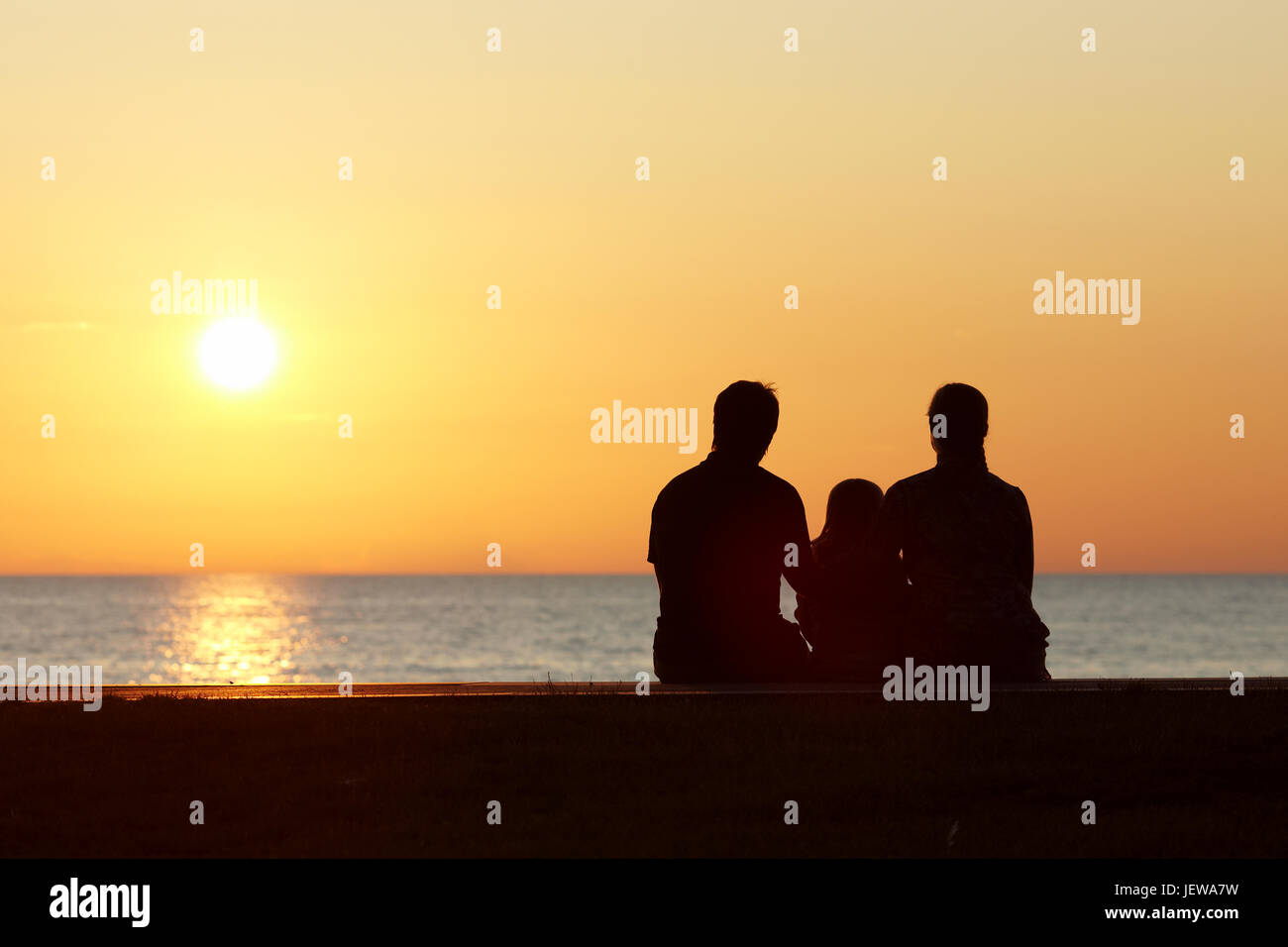 Silhouette of family at sunset Stock Photo - Alamy