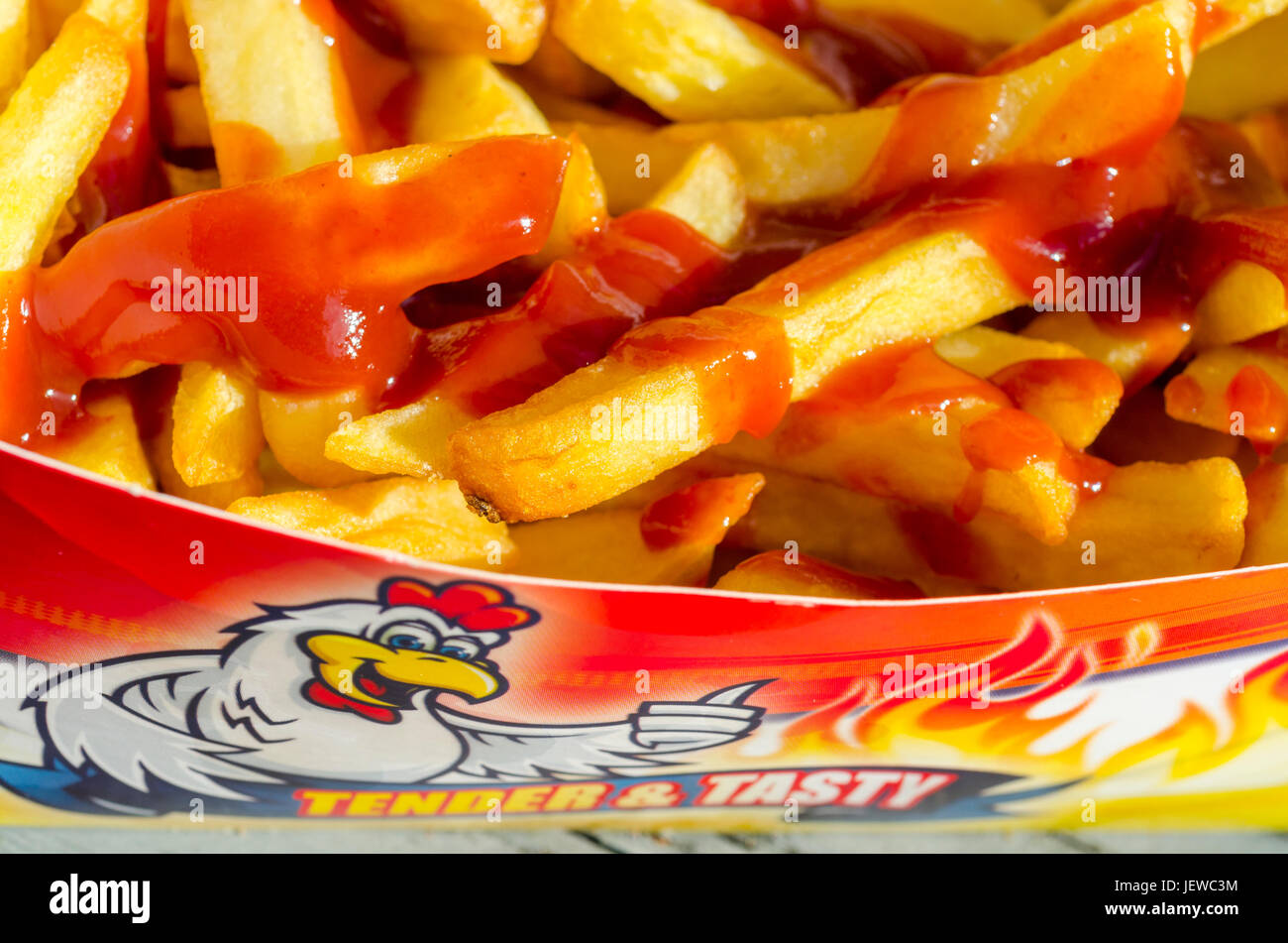 Portion of Take Away Chips with Tomato Sauce Stock Photo