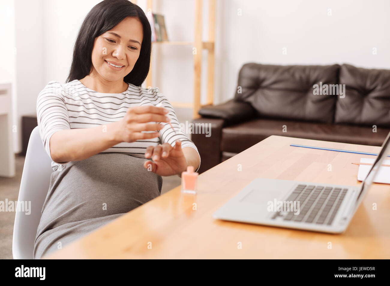 Cheerful pregnant woman painting her nails Stock Photo Alamy