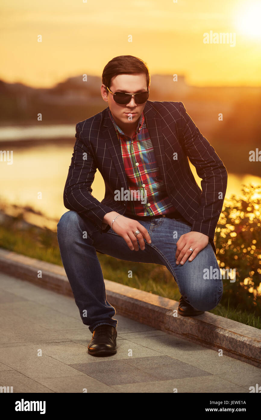 Portrait of young fashion man in sunglasses at sunset Stock Photo