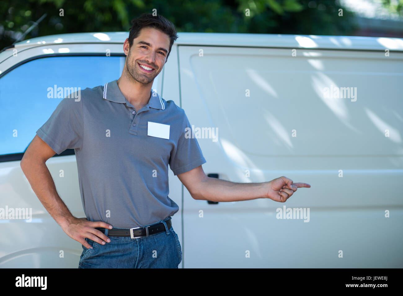 Smiling delivery man pointing van hi-res stock photography and images ...