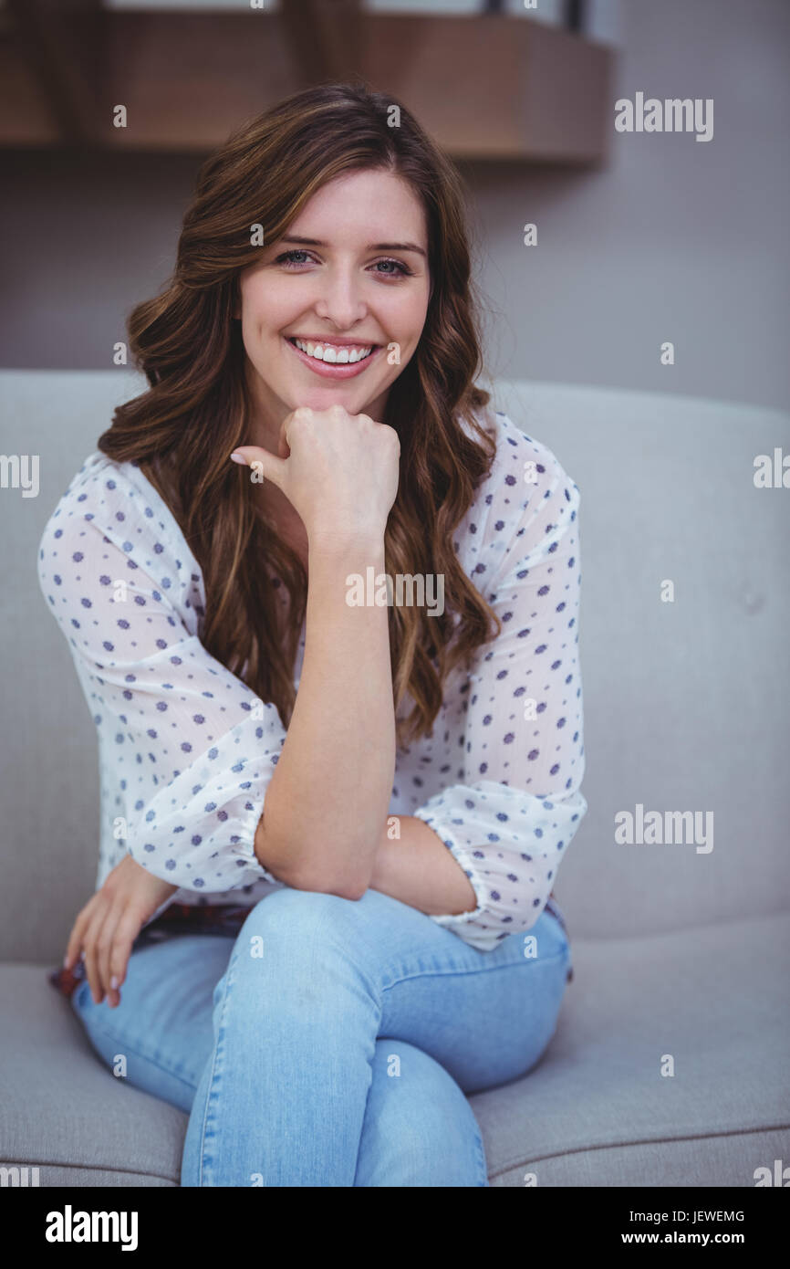 Portrait of beautiful woman sitting on sofa Stock Photo - Alamy