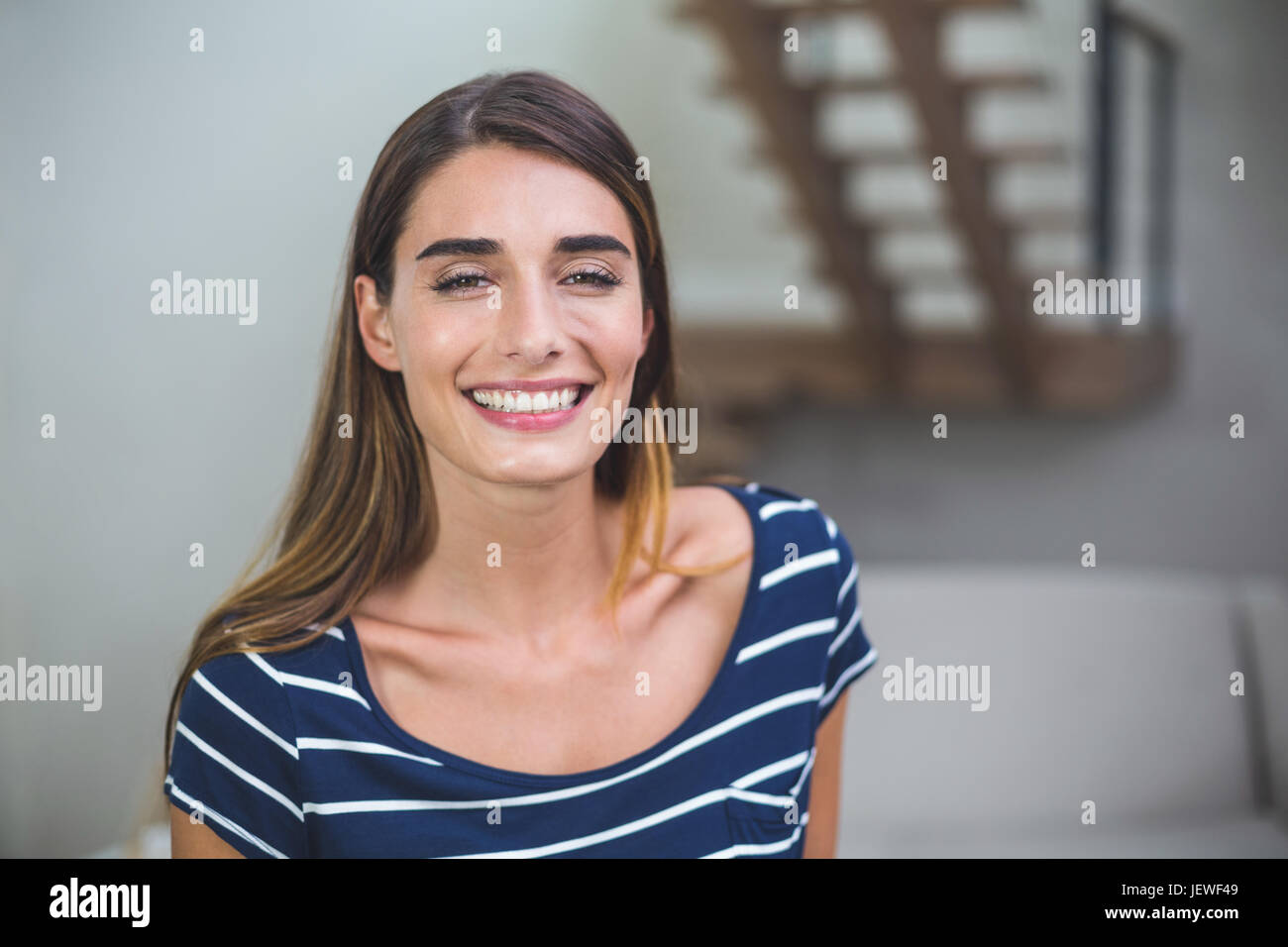 Beautiful woman smiling in living room Stock Photo - Alamy