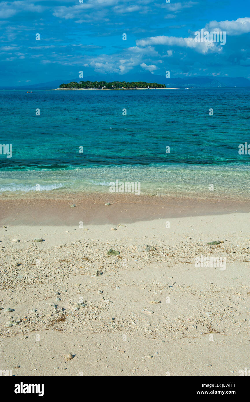 Clear waters on Beachcomber island with a little islet in the background, Mamanucas islands, Fiji, South Pacific Stock Photo